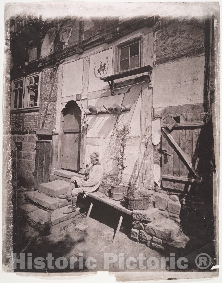 Photo Print : Man Smoking Pipe Outside His Home on Village Street : Vintage Wall Art