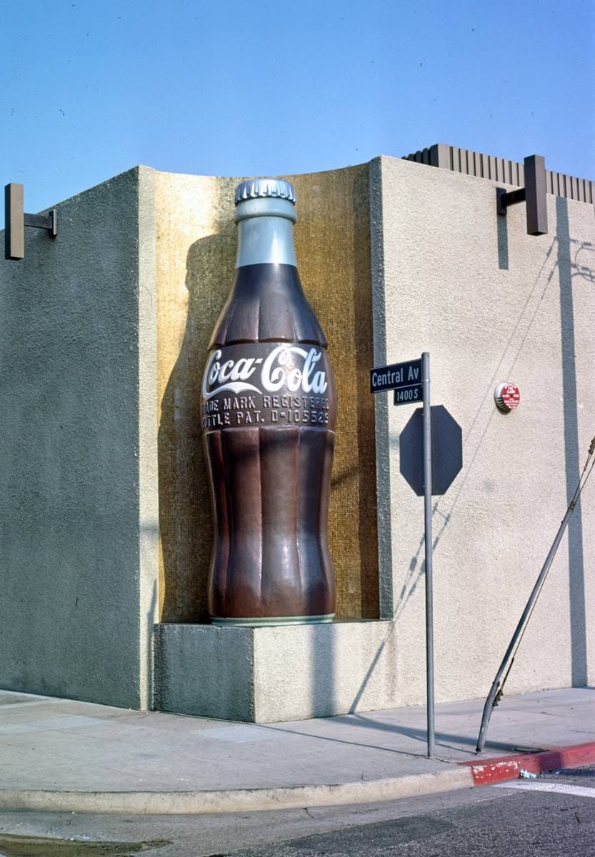 Historic Photo : 1977 Coca Cola Bottling Company, giant Coke bottle corner detail, 14th & Central Avenue, Los Angeles, California | Photo by: John Margolies |