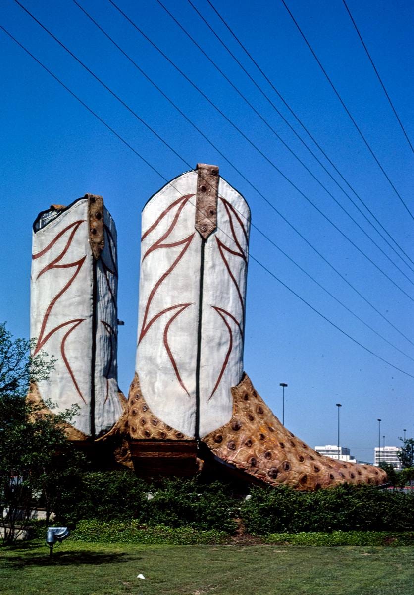Historic Photo : 1982 Largest cowboy boots, Access Road, I-410 [i.e. "Biggest Cowboy Boots in the World"],  San Antonio, Texas | Photo by: John Margolies |