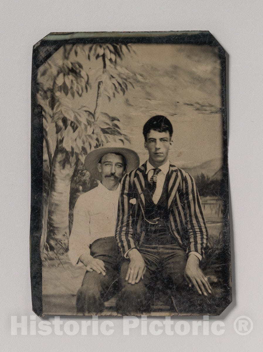 Art Print : Young Man in a Striped Jacket, Sitting on The Lap of Another Man in Front of Painted Outdoor Backdrop - Artist Unknown : Vintage Wall Art