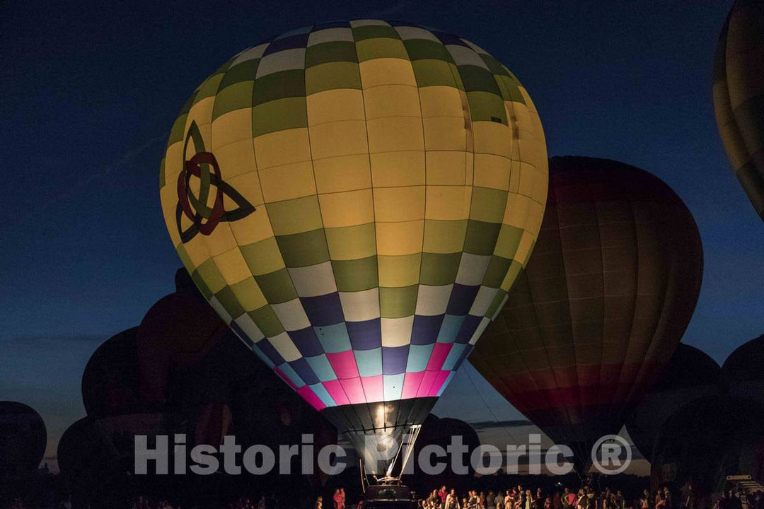 Colorful balloons delight the assembled crowd with a night glow as pilots fire the burners on the ground at the National Balloon Classic,  2