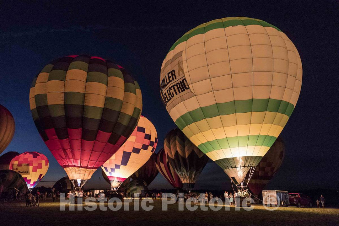 Colorful balloons delight the assembled crowd with a night glow as pilots fire the burners on the ground at the National Balloon Classic,  4