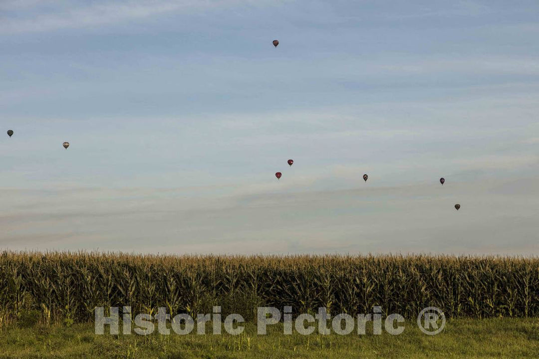 Colorful balloons delight the assembled crowd with a night glow as pilots fire the burners on the ground at the National Balloon Classic,  8