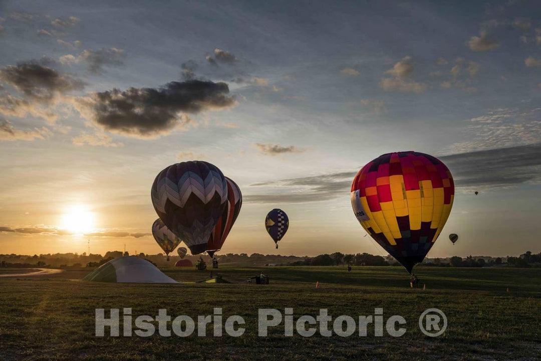Colorful balloons delight the assembled crowd with a night glow as pilots fire the burners on the ground at the National Balloon Classic,  9