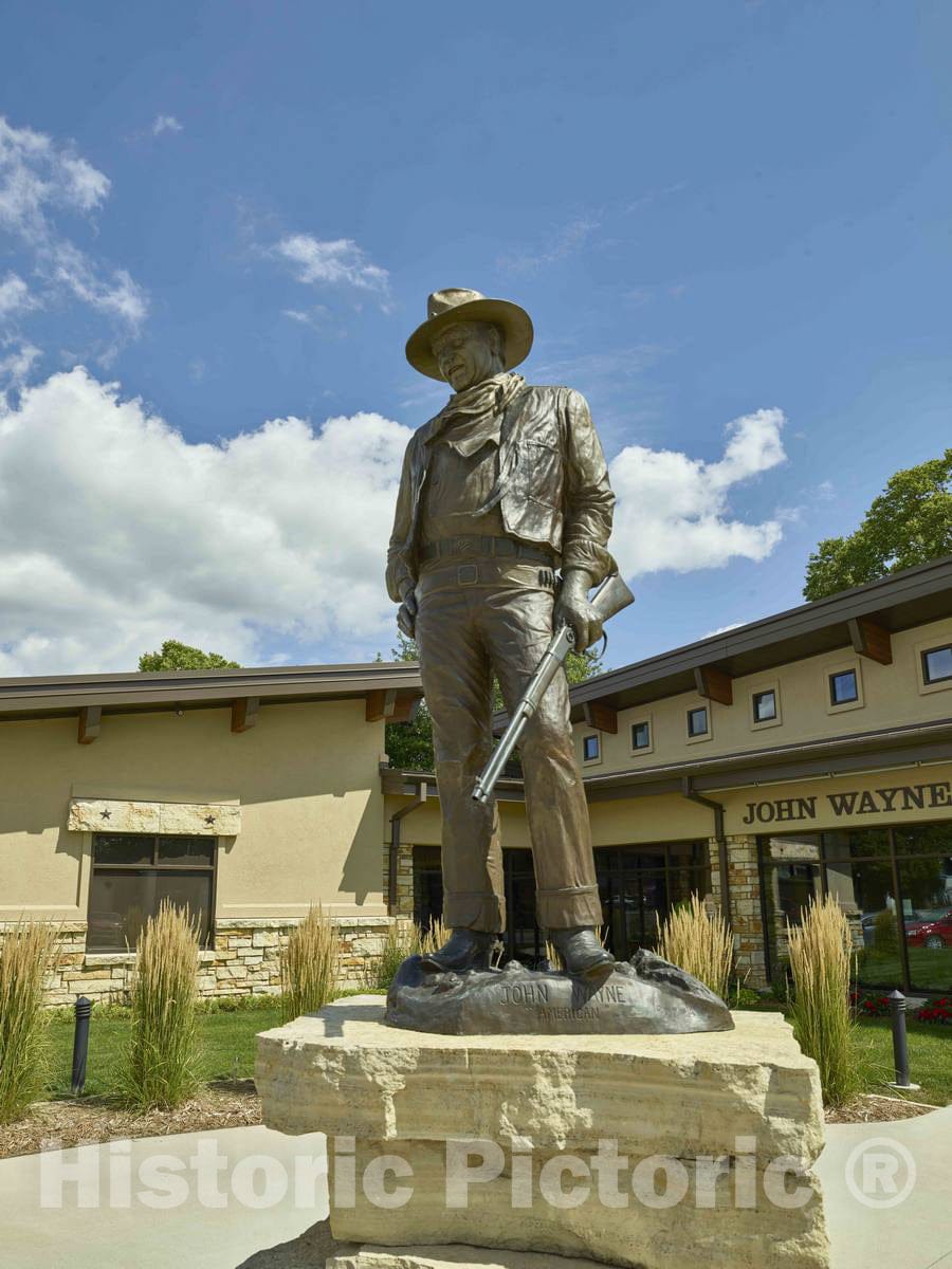 Photo- Statue of The Legendary Hollywood Actor Outside The John Wayne Birthplace Museum, on John Wayne Drive in Winterset, Iowa. The Birth Home Stands Behind The Museum