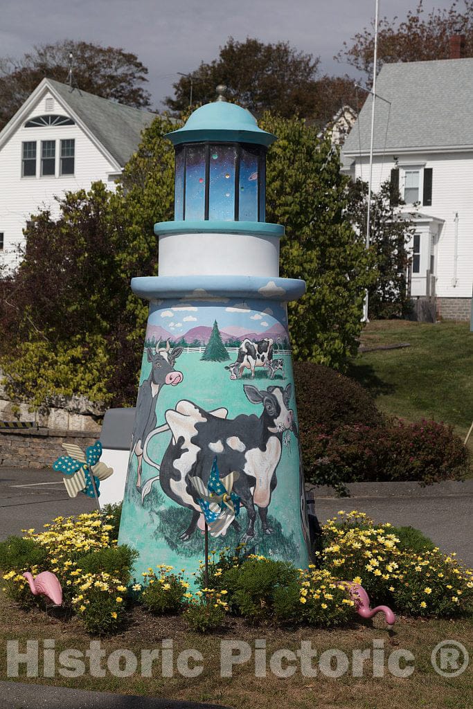 Photo- A decorative lighthouse, appropriate for the seaport town of Boothbay, Maine. The cow figure, however, is more suggestive of another northern New England state, Vermont