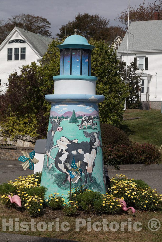 Photo- A decorative lighthouse, appropriate for the seaport town of Boothbay, Maine. The cow figure, however, is more suggestive of another northern New England state, Vermont