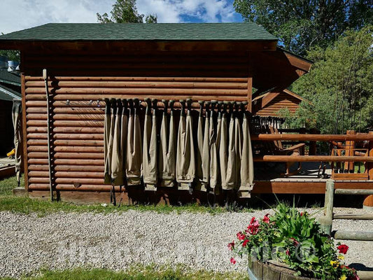 Photo- Chest-high boots called waders hang from the A Bar A ranch's fish shack, puckishly called the Liars' Lair, fishers are prone to exaggerating the size of fish caught 2