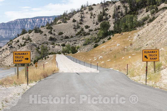 Photograph- Signs for, and escape ramps of, runaway-truck installations such as this one in remote Big Horn County, Wyoming, are a common sight throughout the northern Rocky Mountains Drivers